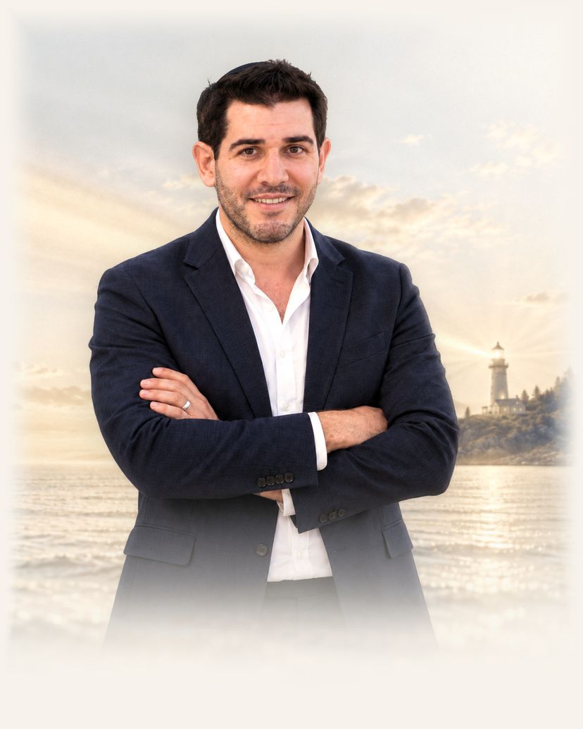 ליאור סופר מדבר במיקרופון מול הים, ומאחוריו מגדלור שקרן האור שלו חוצה את השמיים